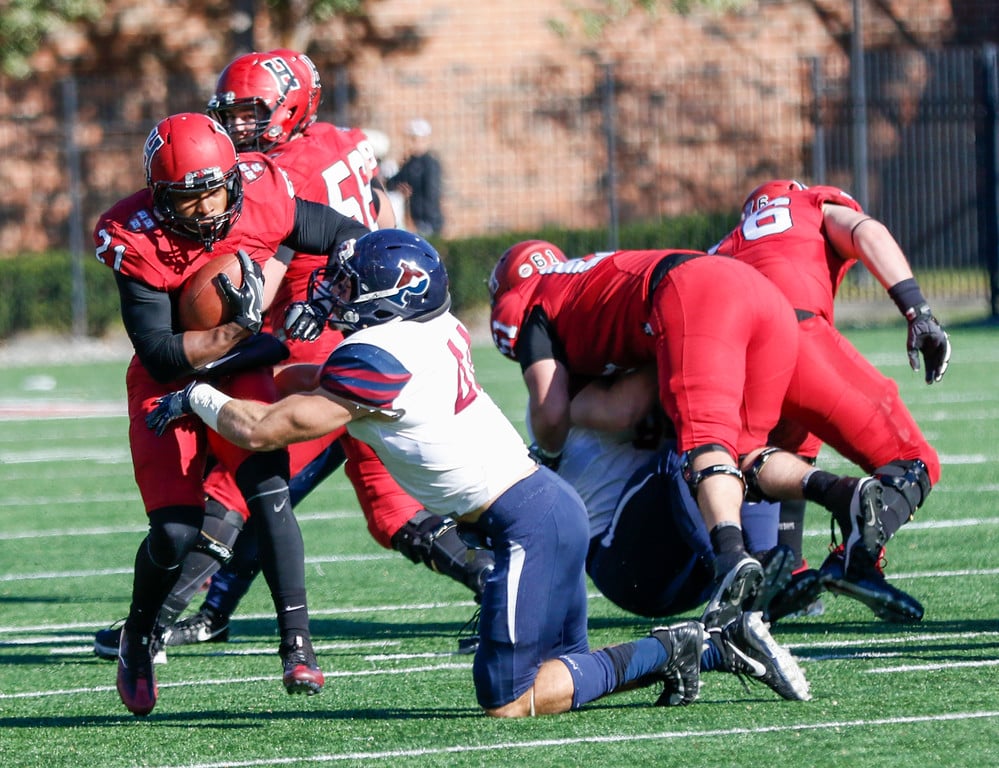 Senior running back Charlie Booker III fights off a tackle as the offensive line bulldozes a path.