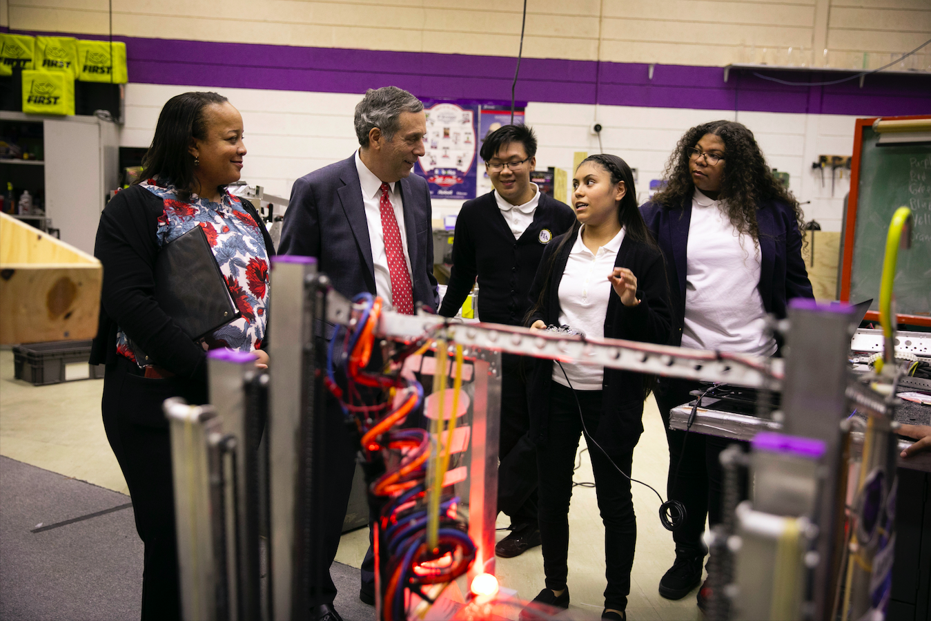 Students at International Technology Academy in Pontiac, Michigan give President Bacow and HGSE Dean Long a tour of the Robotics Lab.