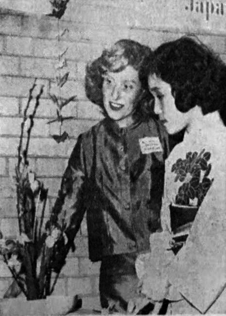 President of Harvard Dames, Patricia I. Seldner (Mrs. MacElliot Seldner), admires a flower arrangement done by another Dames member (Mrs. Fukiko Shinohara).