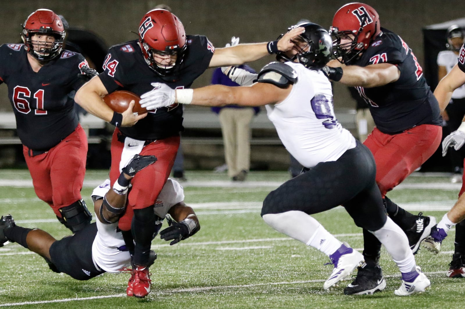 Quarterback Tom Stewart puts down a nice stiff-arm as he shakes off two tackles in Friday night's contest with Holy Cross.
