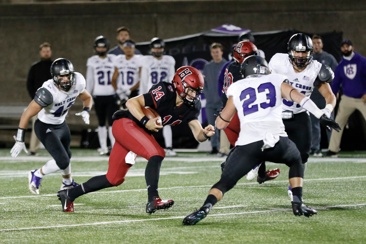 Senior quarterback Tom Stewart lowers his shoulder and braces for a hit against Holy Cross.