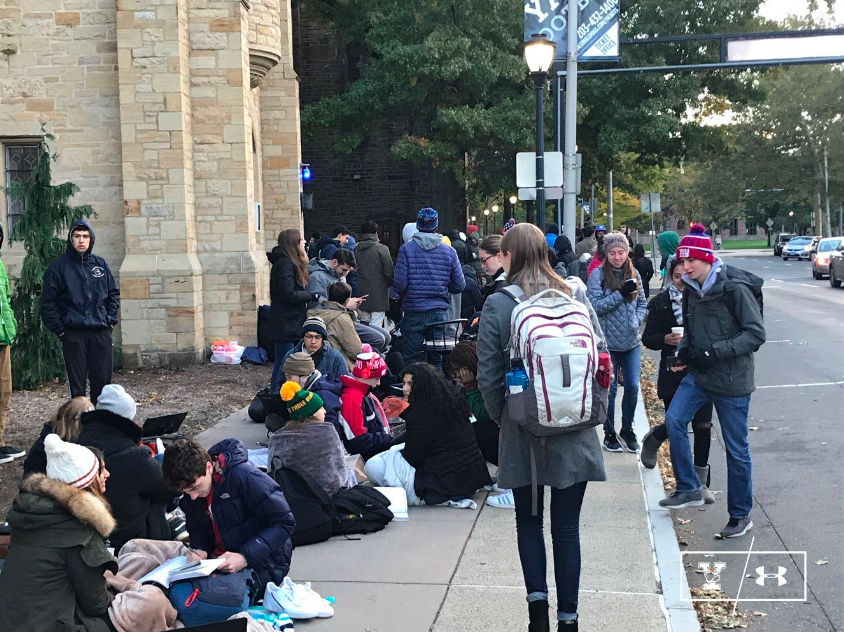 Students camp out in the cold, preoccupying themselves with homework.