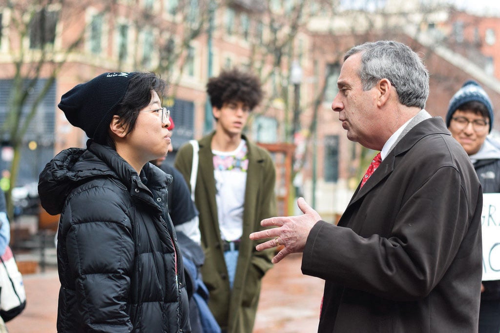 University President Lawrence S. Bacow speaks to Sally Chen '19 at a demonstration Friday where students and alumni called on Harvard to create an Ethnic Studies program.