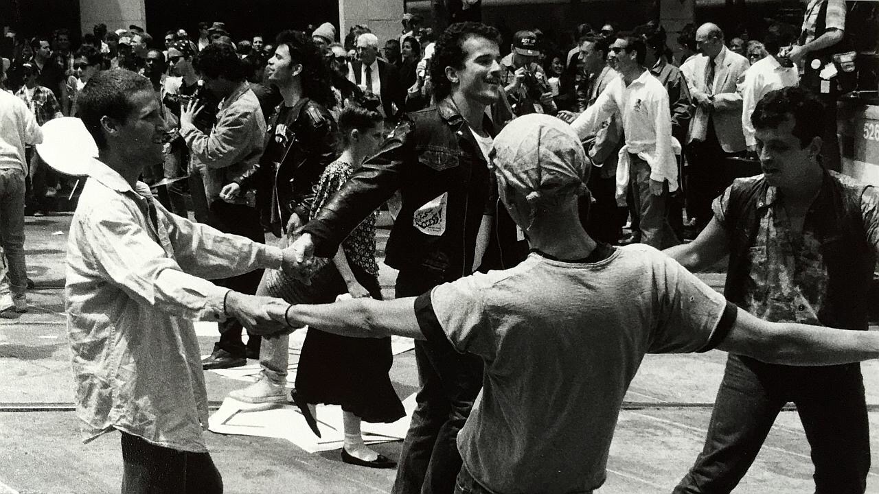At the 1990 International AIDS conference in San Francisco, a group of activists, including Aldyn J. B. McKean ’70, hold hands.