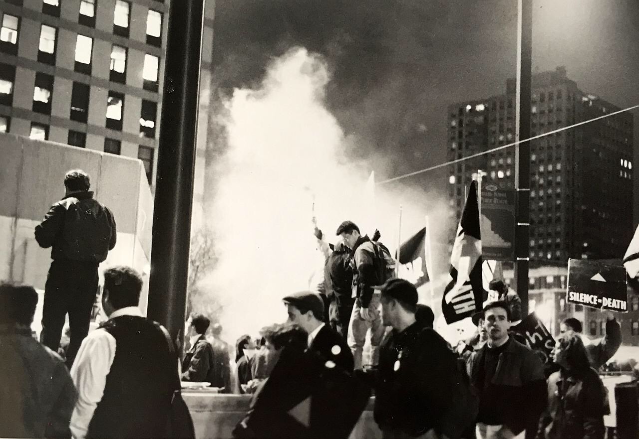 A plume of smoke emerges from a crowd at a Harvard Medical School protest.