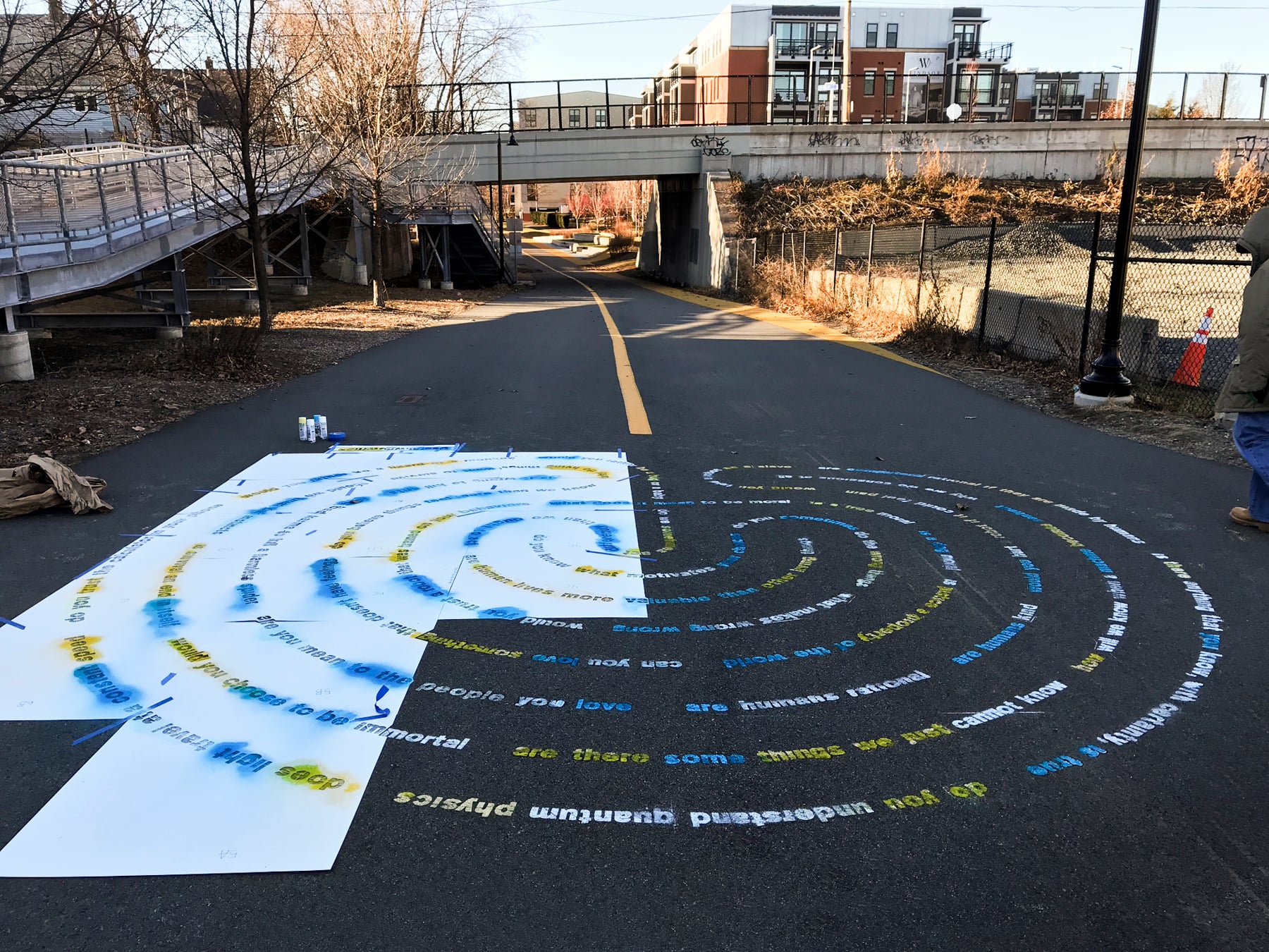 Progress of Moral Labyrinth's installation in which colorful chalk is sprayed onto the pavement.