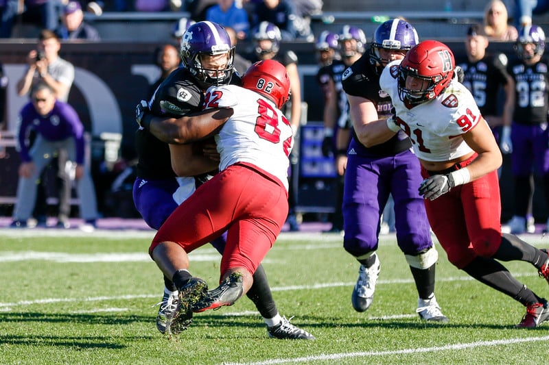 Sophomore defensive lineman Anthony Nelson wraps up the Holy Cross quarterback for one of five team sacks.