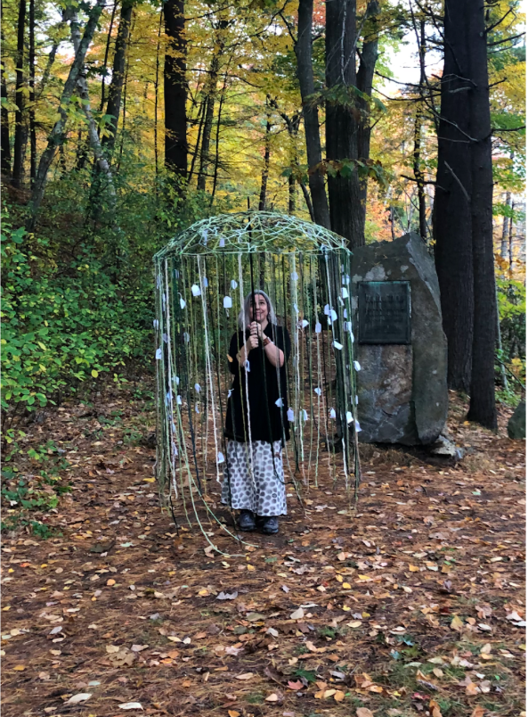 Artist Karen Krolak stands underneath an umbrella tagged with the names of audience members' loved ones.