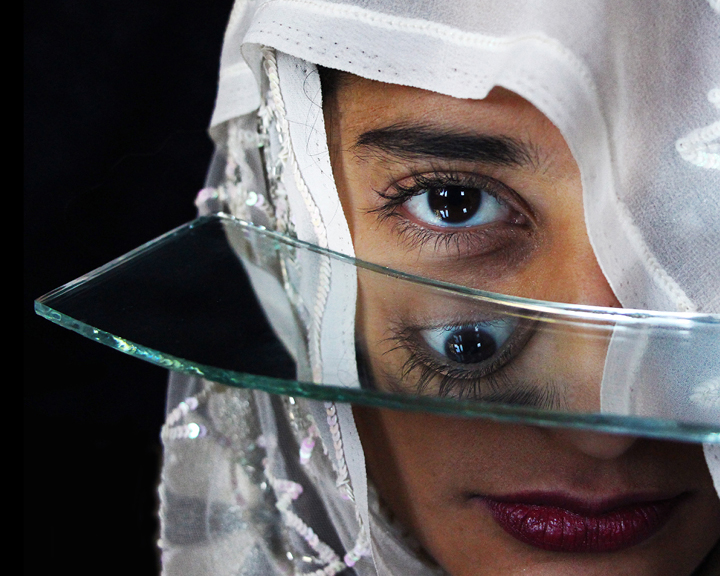 Another entry is a series of self portraits taken by Rawji herself entitled “both and”. In the photographs, she poses with shards of a broken mirror which reflect fragments of her face.