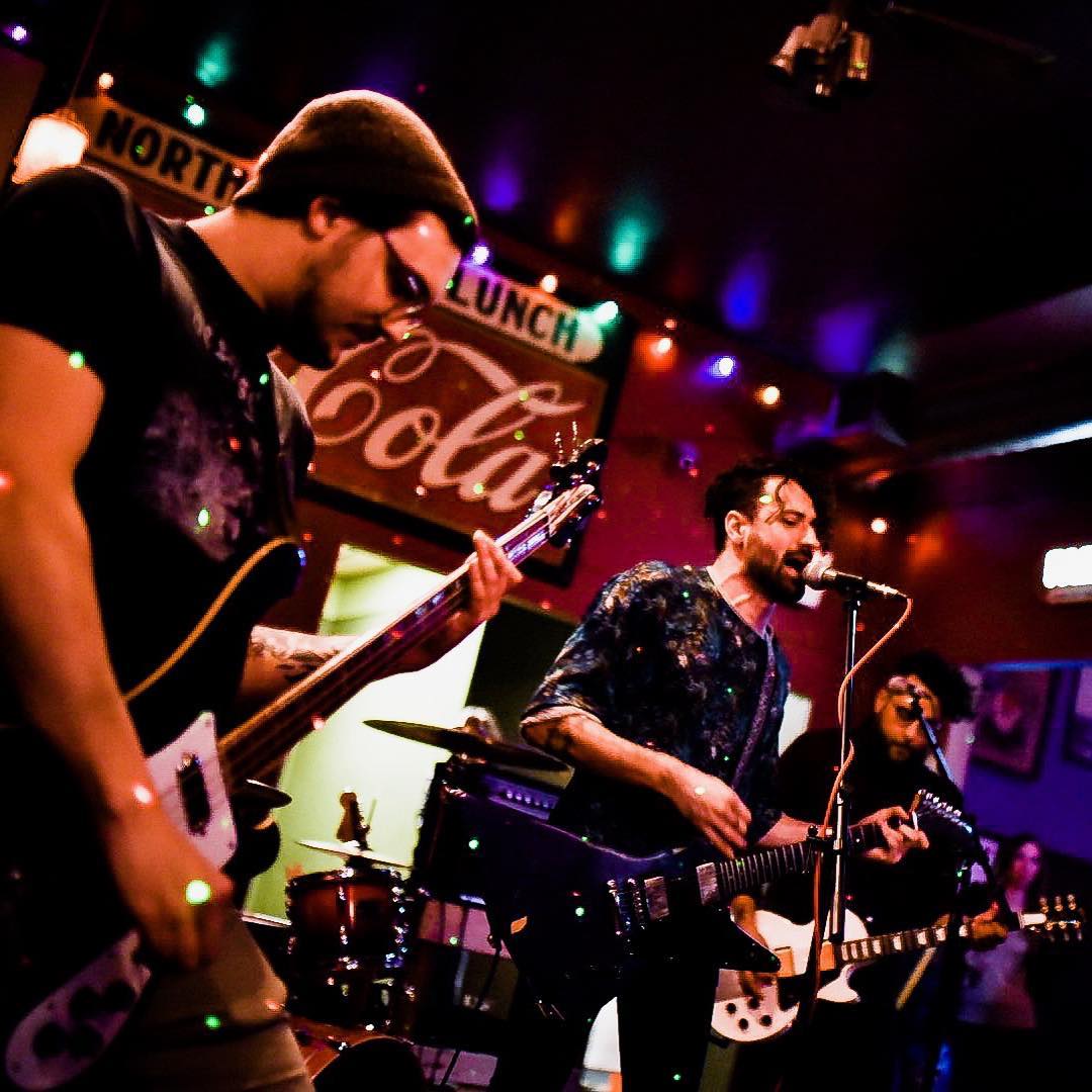Nick J. Grieco (center), an Allston based musician, playing the guitar.