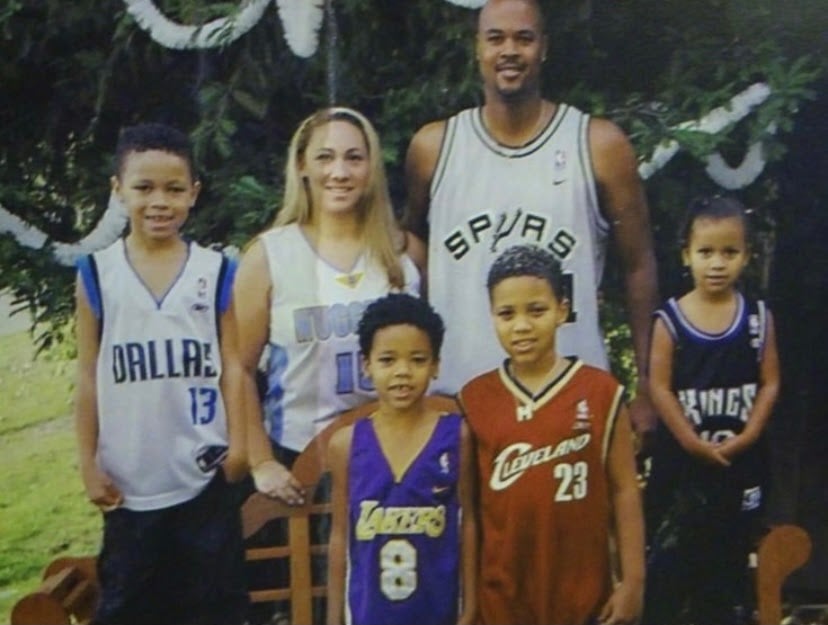 The Forbes family gathers for a photo, with each member wearing a different NBA jersey.