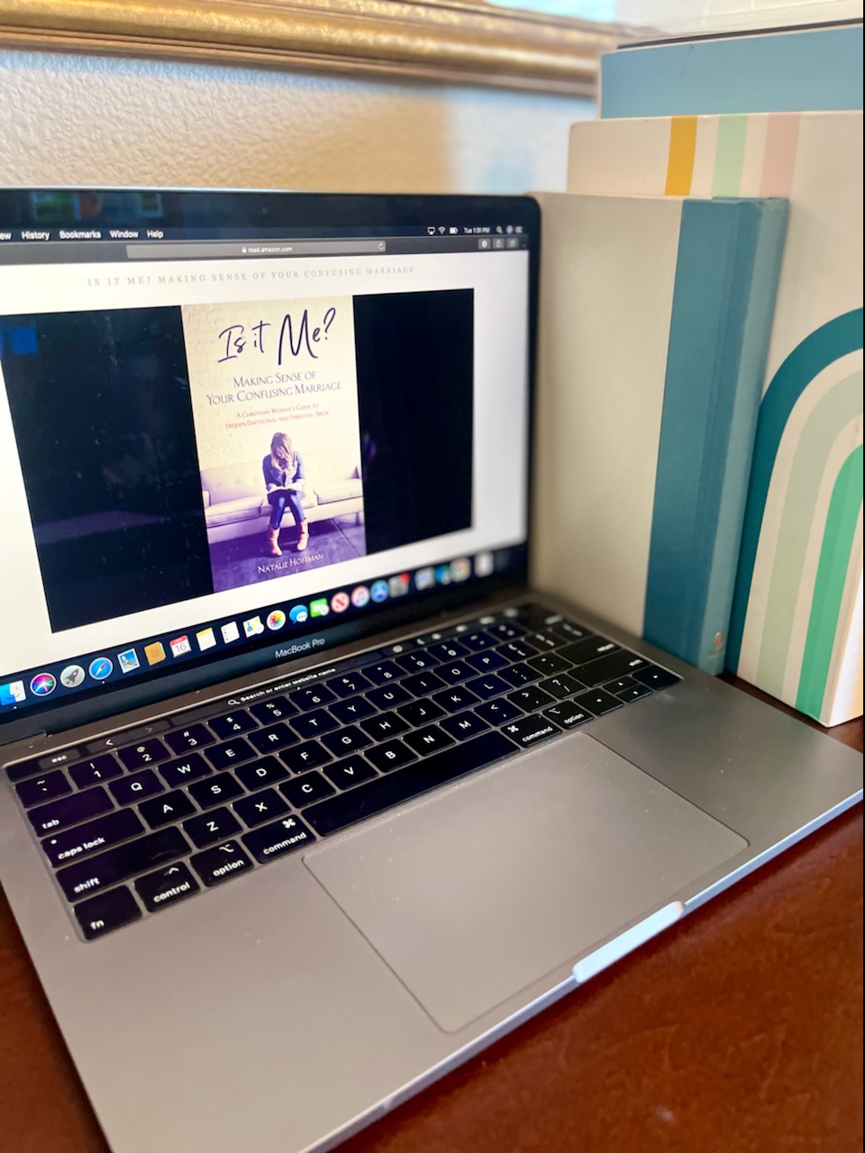 A photo of Katherine's laptop as she opens "Is it Me? Making Sense of Your Confusing Marriage: A Christian Woman’s Guide to Hidden Emotional and Spiritual Abuse," by Natalie Hoffman.