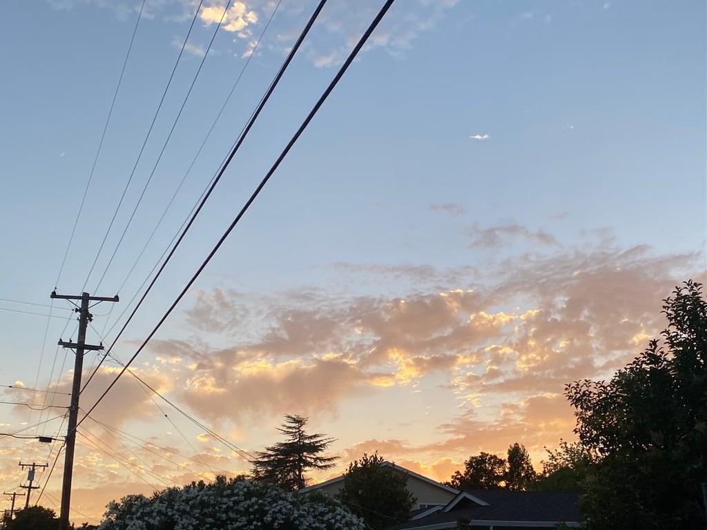 Sunset paints the clouds a pale orange near the author's house in California.