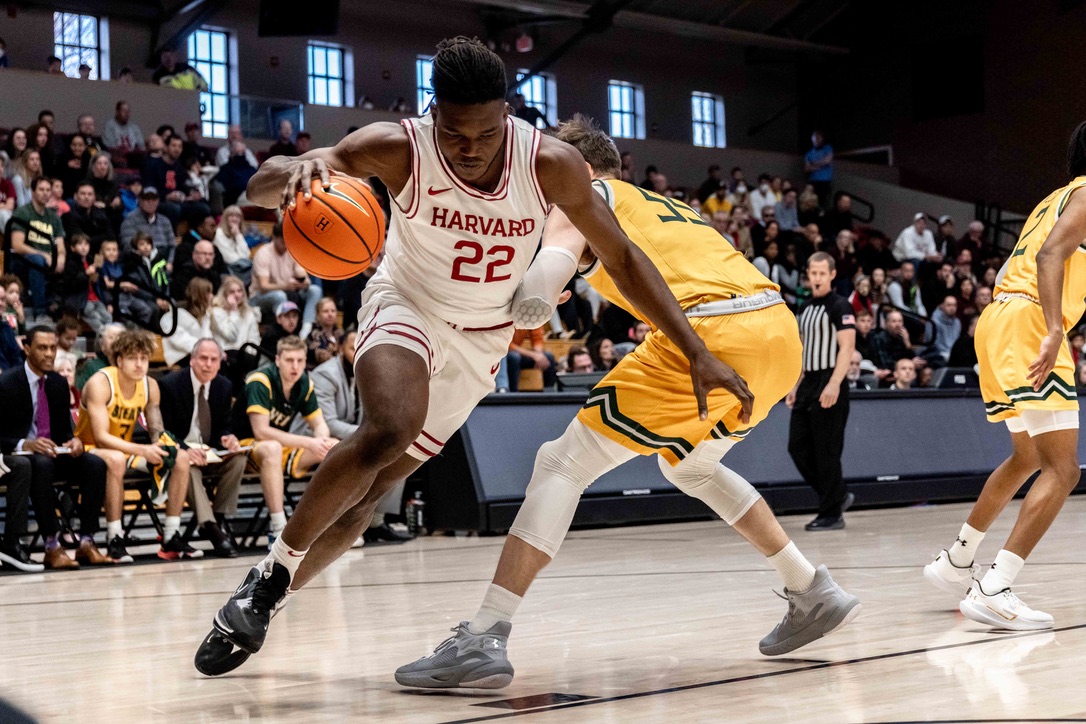 Junior forward Justice Ajogbor drives to the net against a Siena College defender in Harvard's 2022-2023 home opener.