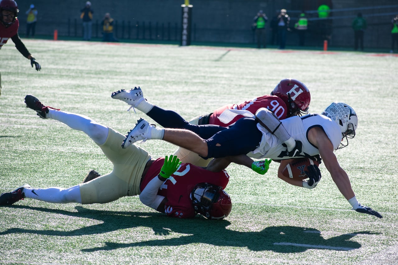 Jones tackles a Yale player at the 2022 annual Harvard-Yale game. The defensive lineman was a unanimous First-Team All-Ivy select and was ranked fourth nationally for blocked kicks in 2022.