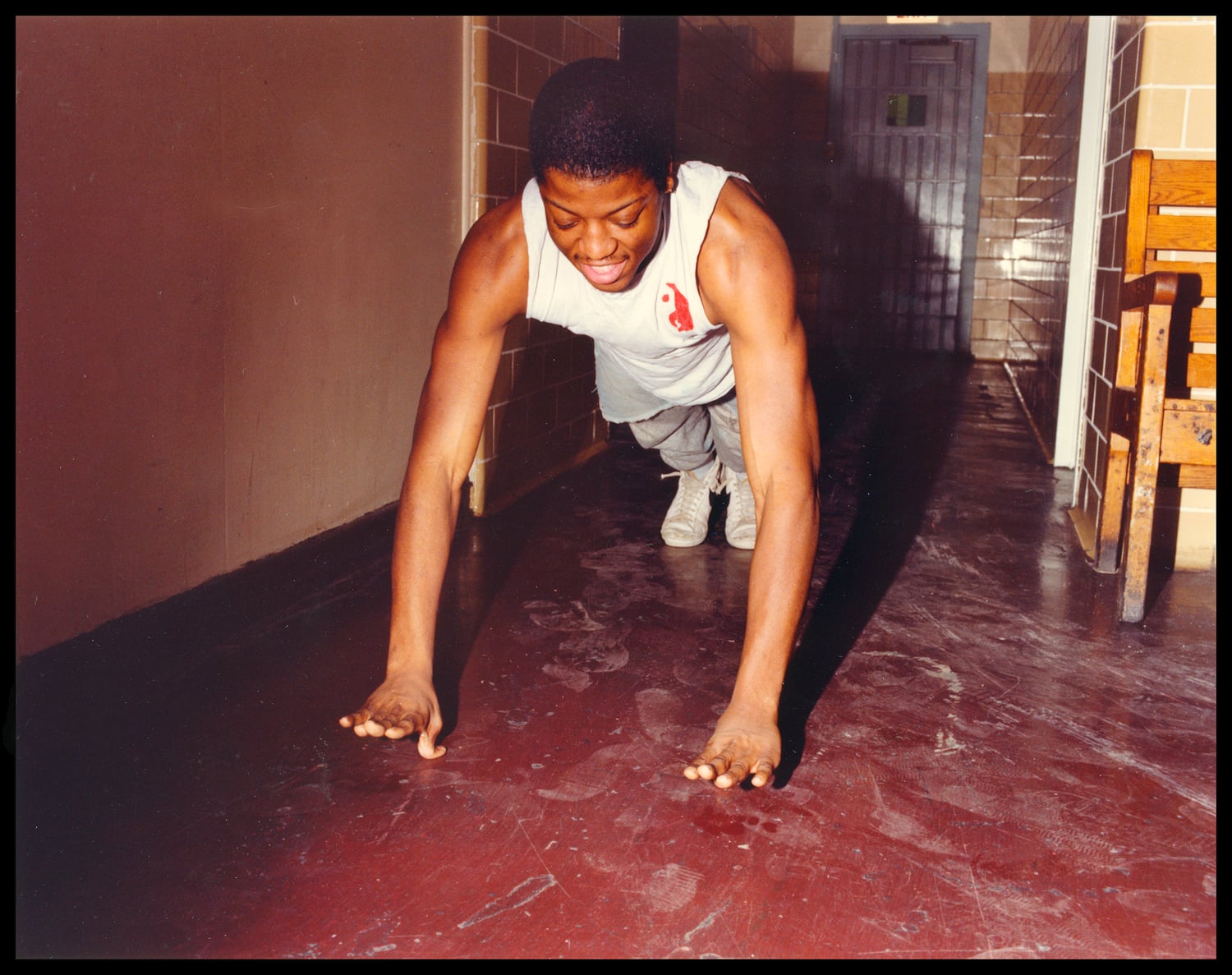 A man incarcerated at Walpole does push-ups in a hallway.