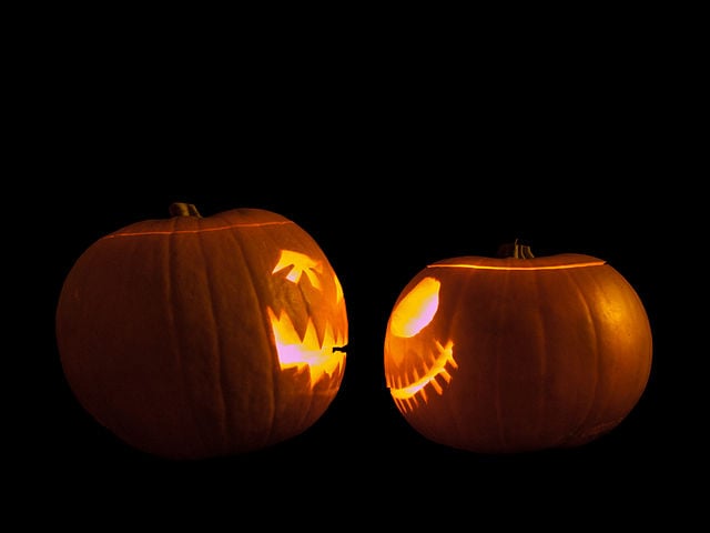 Two Jack-o'-lanterns face off in preparation for watching the best Halloween TV episodes.