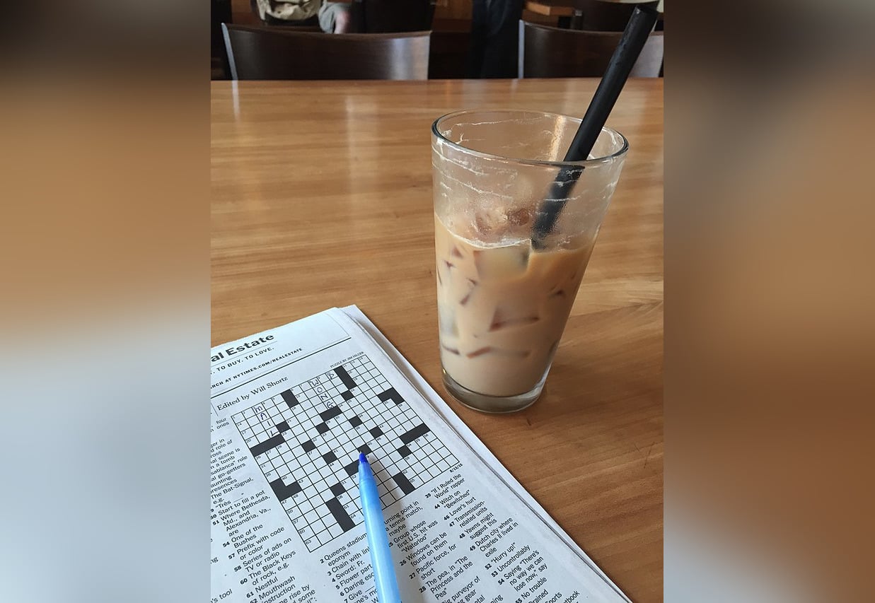 Iced latte and The New York Times crossword puzzle in a cafe in Seattle, Washington.