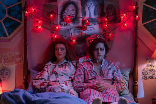 Kathryn Newton and Cole Sprouse sitting on a bed in "Lisa Frankenstein"