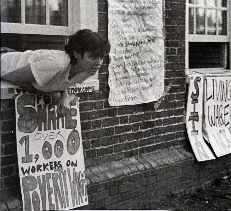 A protester hangs out of a window during the Progressive Student Labor Movement's 2001 sit-in at Massachusetts Hall.