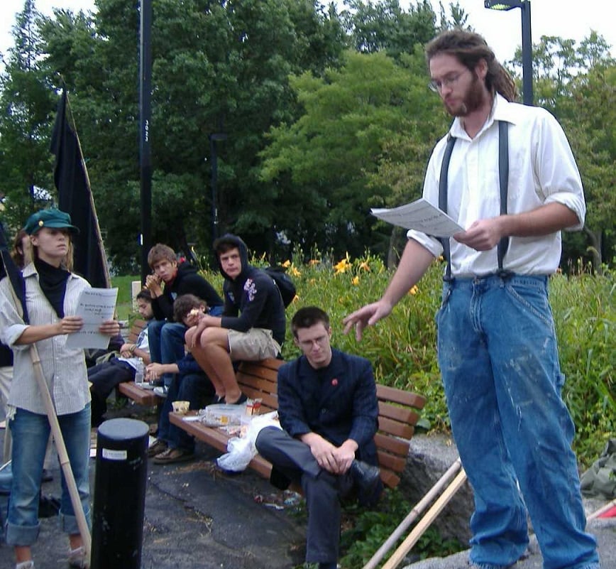 A 2006 Sacco and Vanzetti Commemoration Parade attendee reads to the protesters.