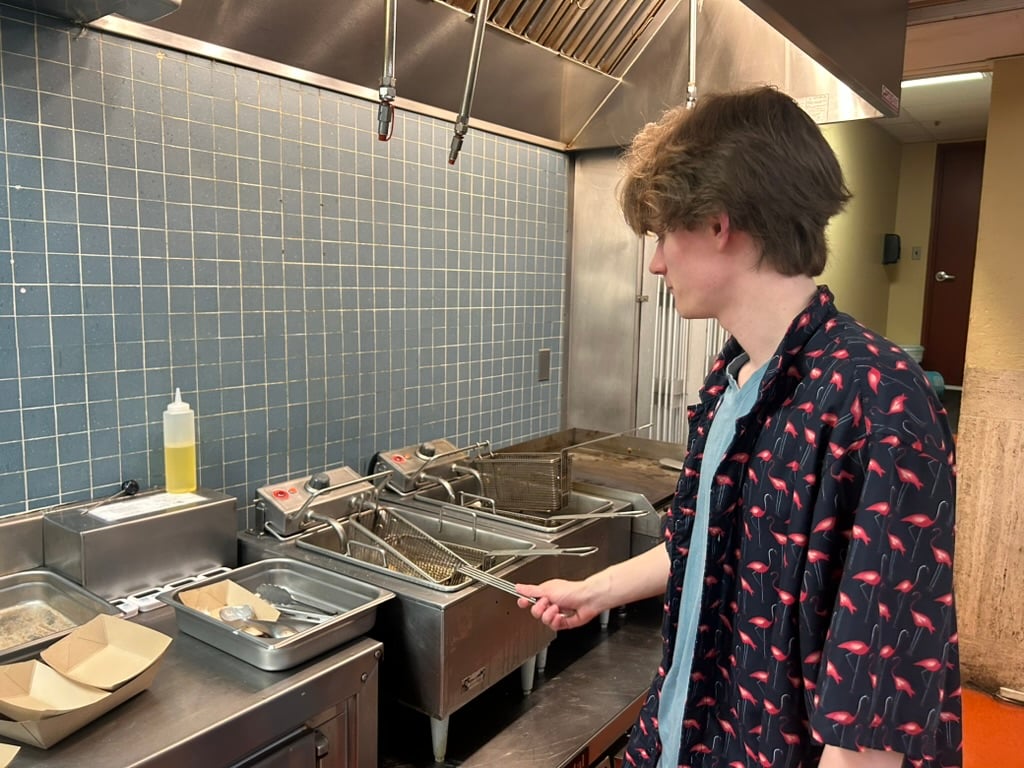 Current Quincy Grille co-manager Caleb A. Hultmann ’27 working the deep fryer.