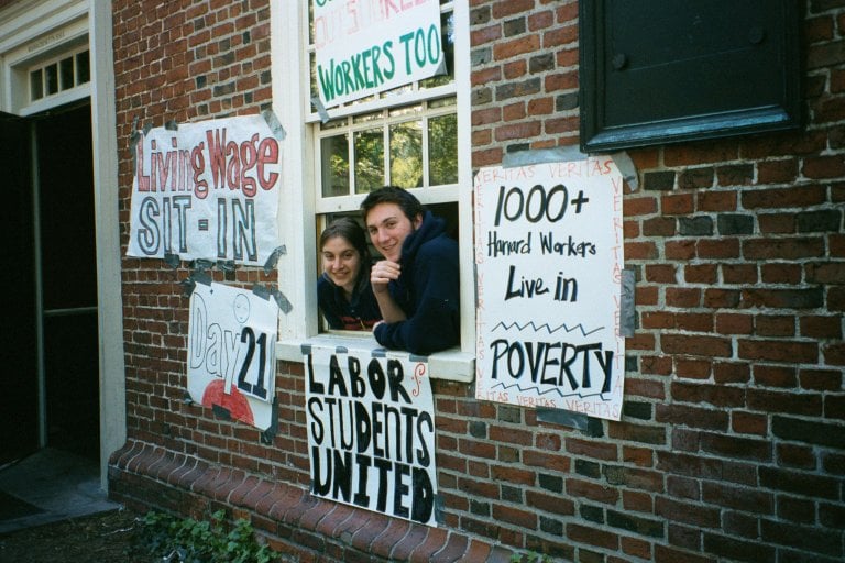 Two students look out from a Massachusetts Hall window during the 2001 living wage sit-in.